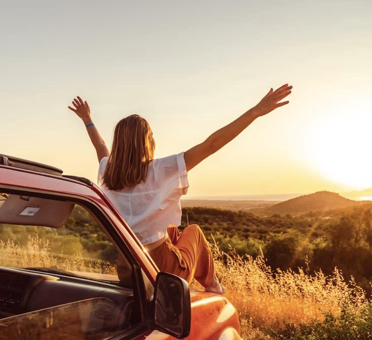 Woman observing sunshine on the car hood